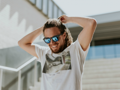 man smiling outside with sunglasses on