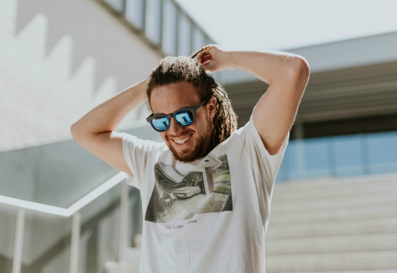 man smiling outside with sunglasses on