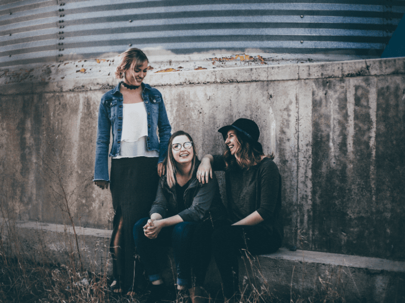 Three young women smiling with each other