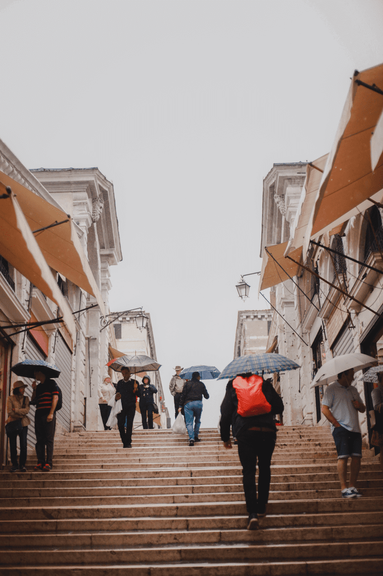 People on stairs with umbrellas 