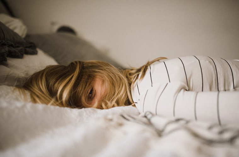 Woman laying face down in bed