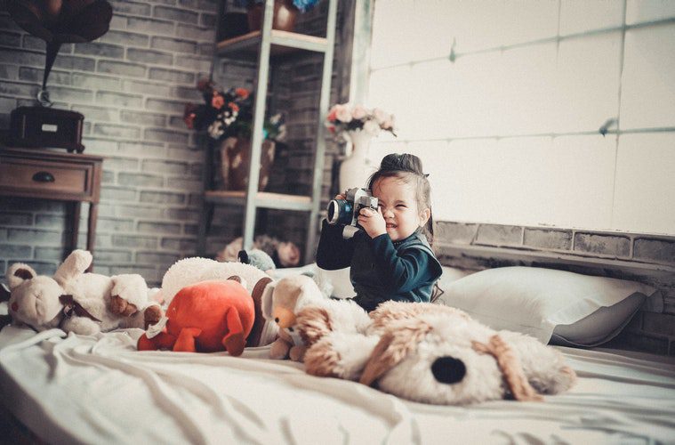 girl on bed with stuffed animals