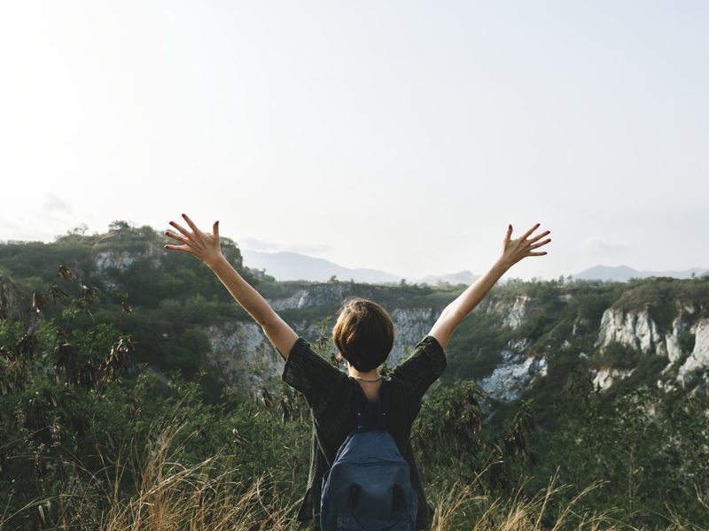 Person raising arms out in nature