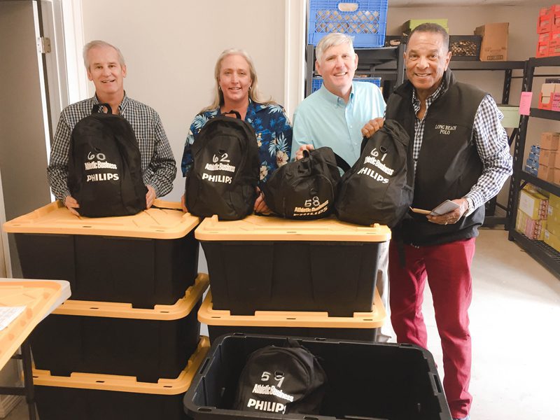 Men and Women holding up backpacks 