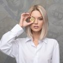 Woman holding gold coin with bitcoin logo