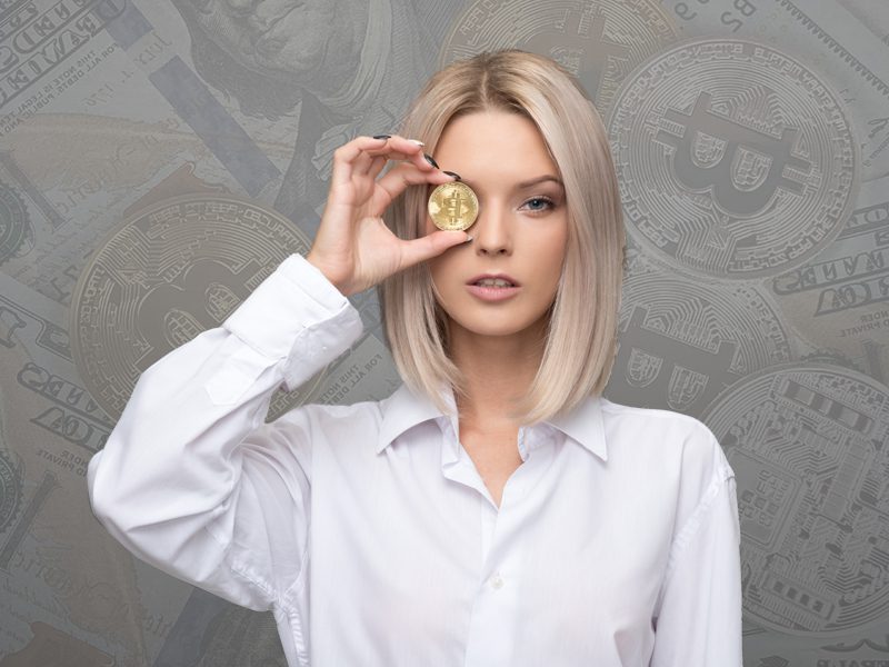 Woman holding gold coin with bitcoin logo