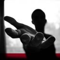 Silhouette of person reaching hand out