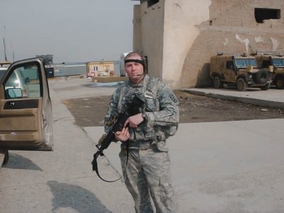 Jesse Posner in soldier uniform holding gun
