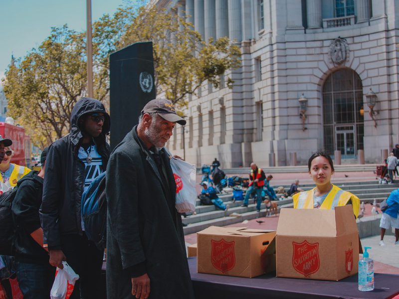 Men in line in front of Salvation Army boxes