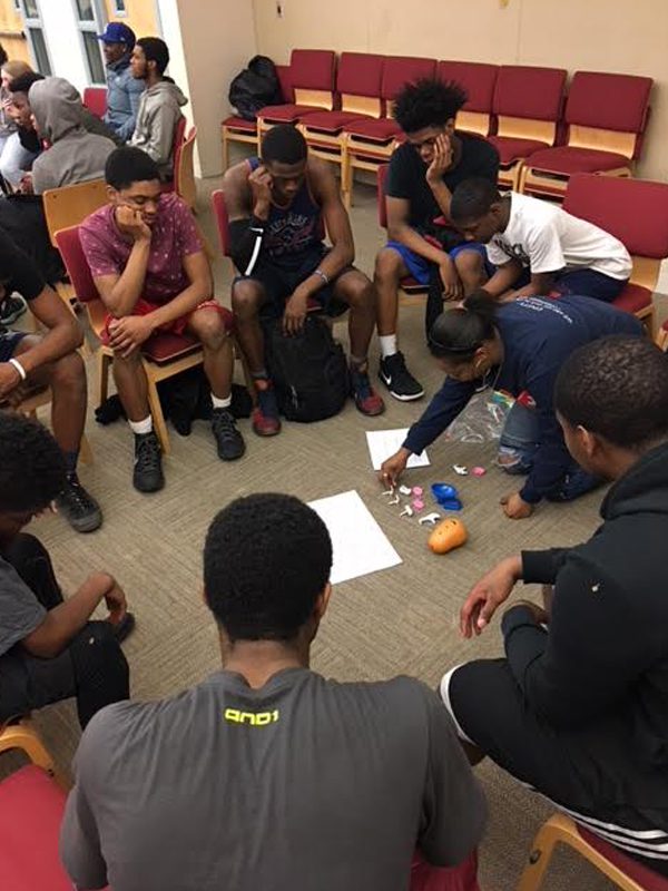 youth sitting on chairs in a circle with mentor