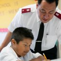 Salvation Army soldier helping child doing homework