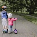 young boy and girl on scooters