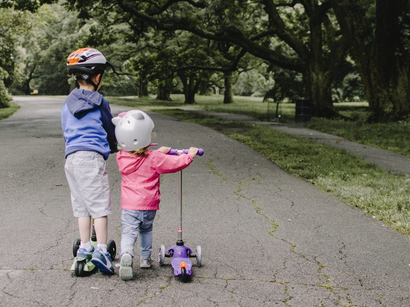 young boy and girl on scooters