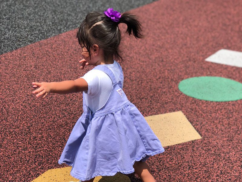 toddler in purple dress playing