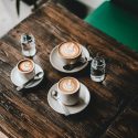 Three coffee cups on wooden table
