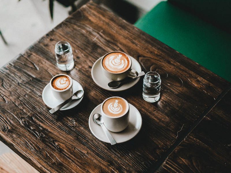 Three coffee cups on wooden table