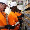 Men in orange shirts and hardhats working