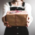 woman holding presents with candy cane wrapping paper
