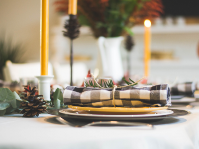 Single table setting on white table cloth in front of candles
