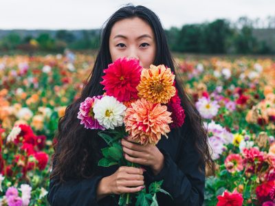 Young Woman holding flowers in front of her face