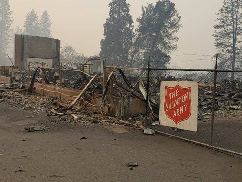 Salvation Army sign in front of burnt down area 