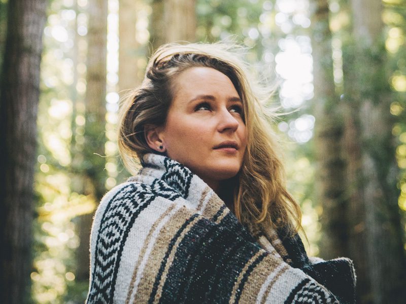 Woman in blanket looking up at sky