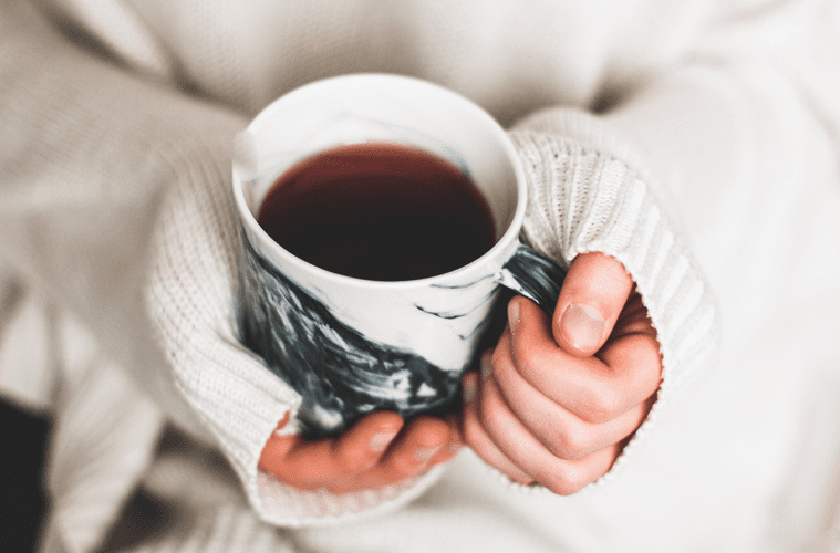 hands holding a cup of coffee