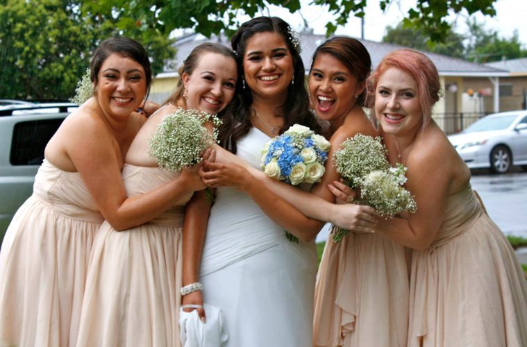 Female Friends Hugging and Smiling Around Bride