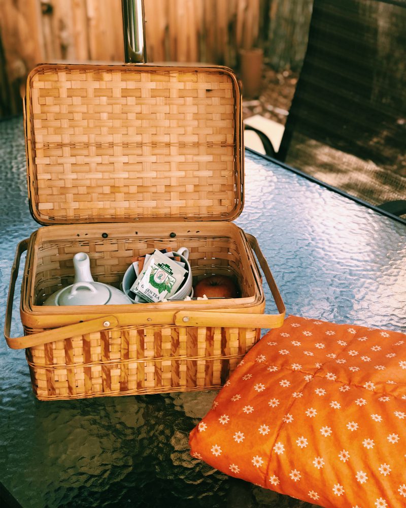 Picnic Basket on Glass Table with Teapot and Tea Packets Inside