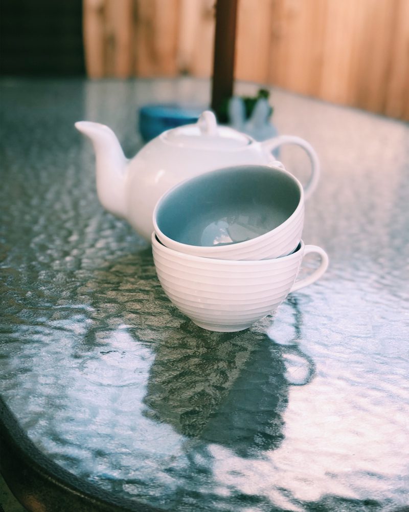 Tea Cups and Teapot on Glass Table