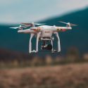 White Drone Flying Over Field