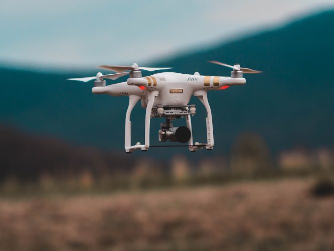 White Drone Flying Over Field