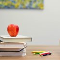 Apple on Books Next to Pencils and Alphabet Blocks