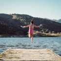 Young Girl Jumping Off Dock into Lake