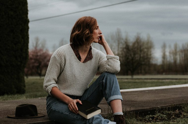 Woman Holding Bible Looking into Distance