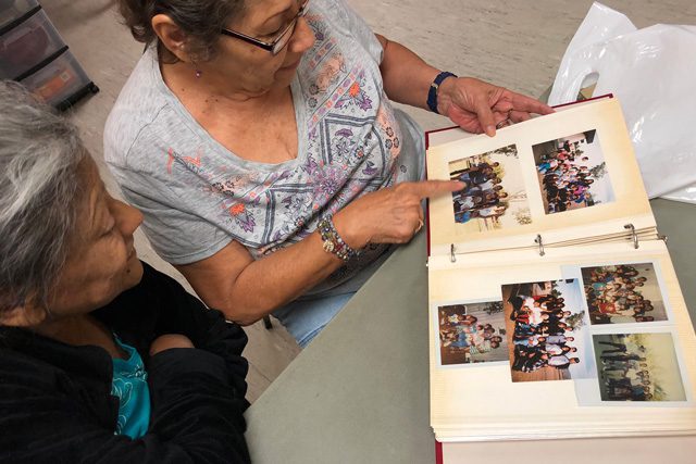 Celia Gonzalez and Maria Botello looking through photo album