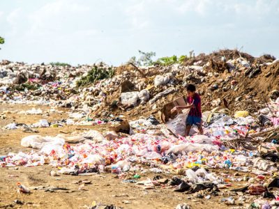 Child Dumping Trash on Beach
