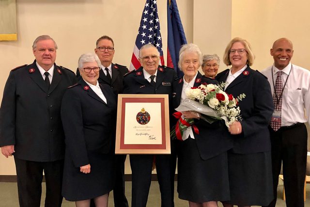 Majors Gerald and Suzanne Hill with group and award