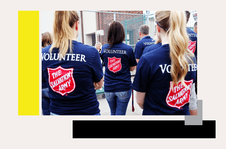 Salvation Army Volunteers with backs turned in volunteer shirts