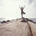 woman doing yoga near the beach