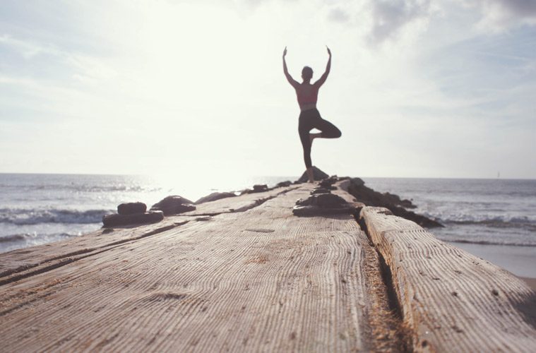 woman doing yoga near the beach