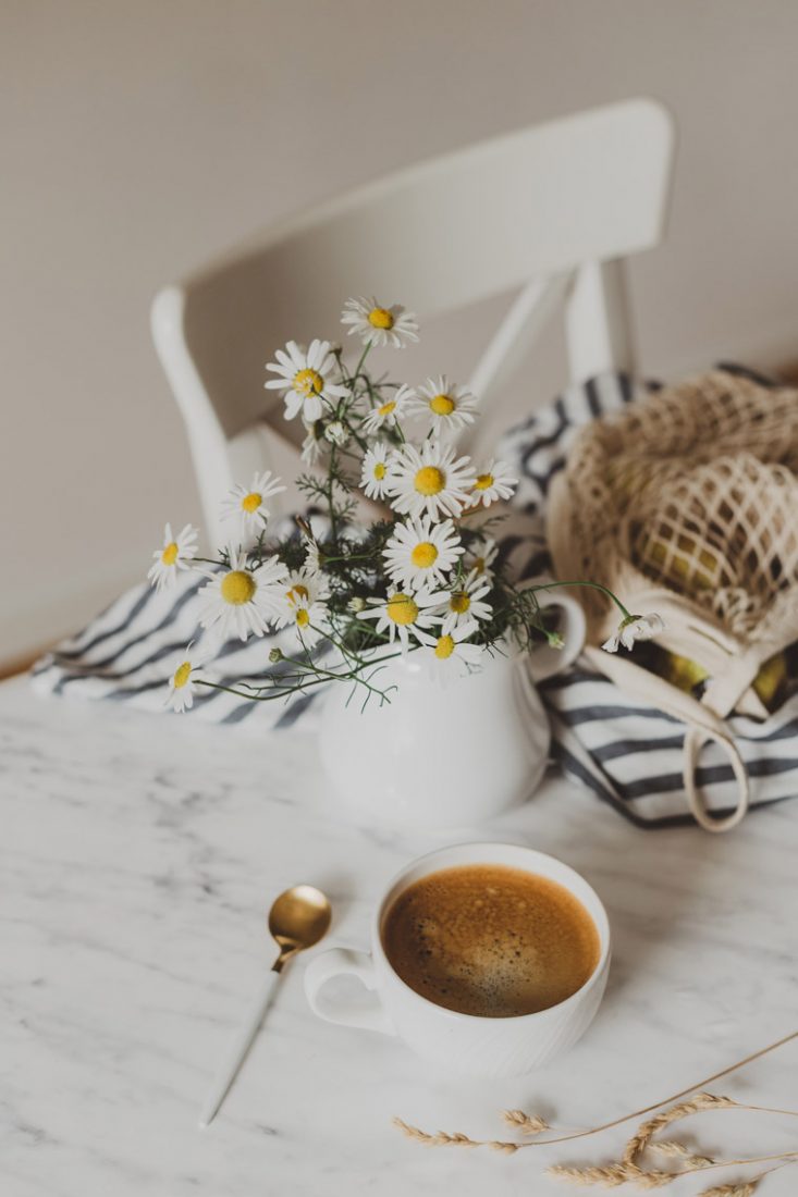flowers and coffee sitting on table