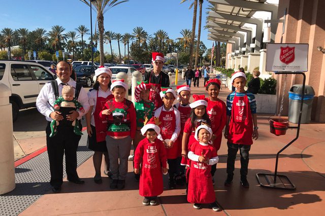 Children in Front of Store as Salvation Army Bellringers