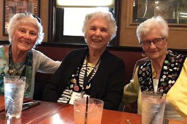 Three TOPS Members Smiling with Water at Table