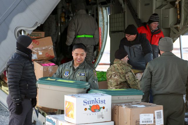 Air and National Guardsmen and Volunteers unload supplies 