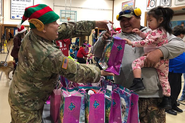 National Guard Member giving Gift Bag to Young Girl