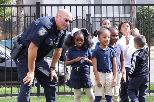 Officer in uniform with children outside