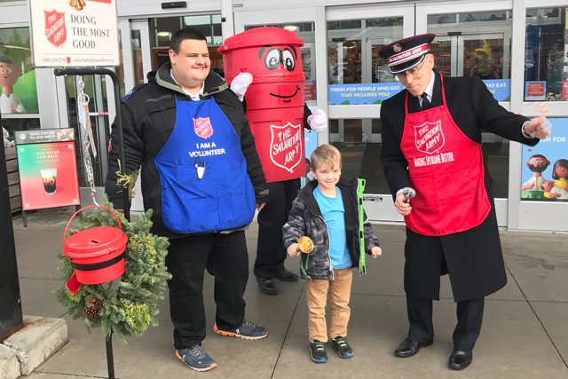 Commissioner Hodder, Harrison, and child ringing kettle bells outside 