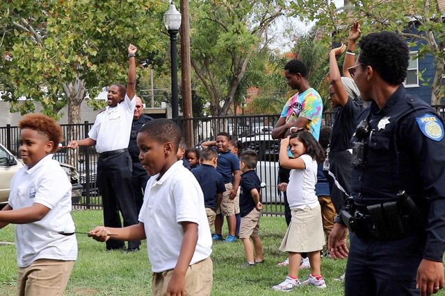 Salvation Army and police officers with children outside