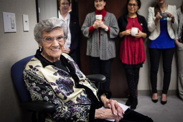 Lemoyne Gooding sitting down and smiling with people clapping behind her